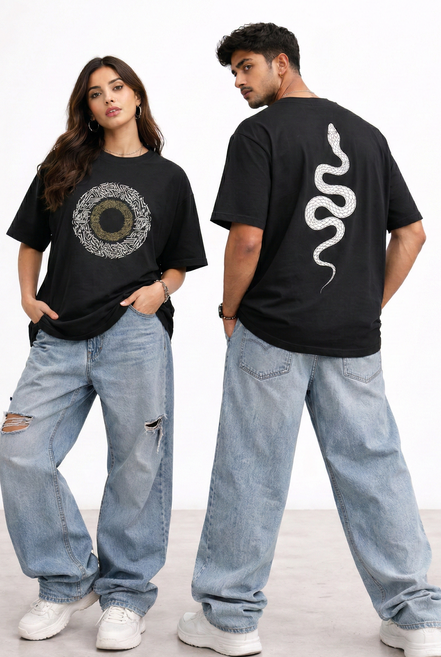 Two people wearing black t-shirts with graphic designs, standing side by side on a light background.