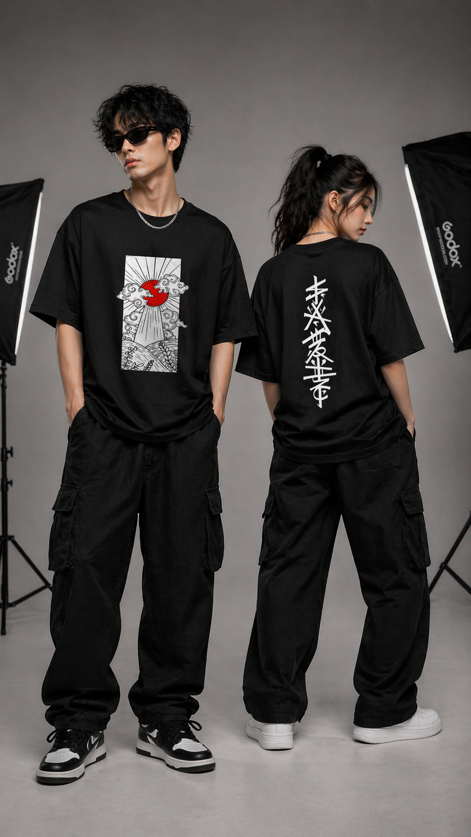 Two people wearing black t-shirts with graphic designs in a studio setting.